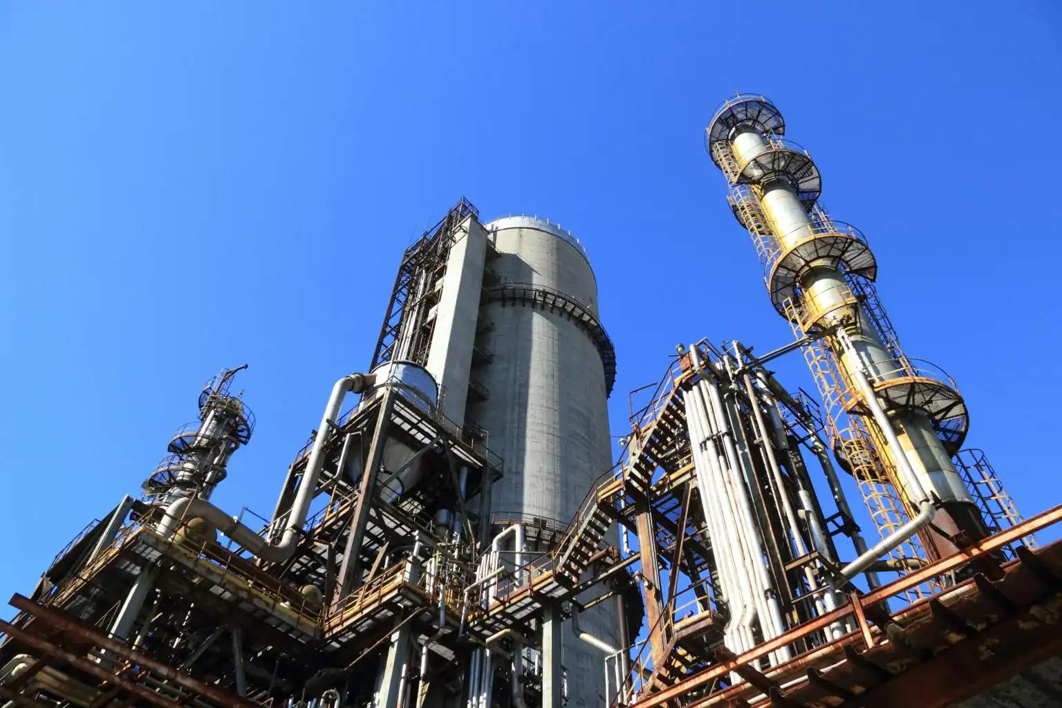 Low-angle view of a modern processing plant with bright lighting and metal cladding.