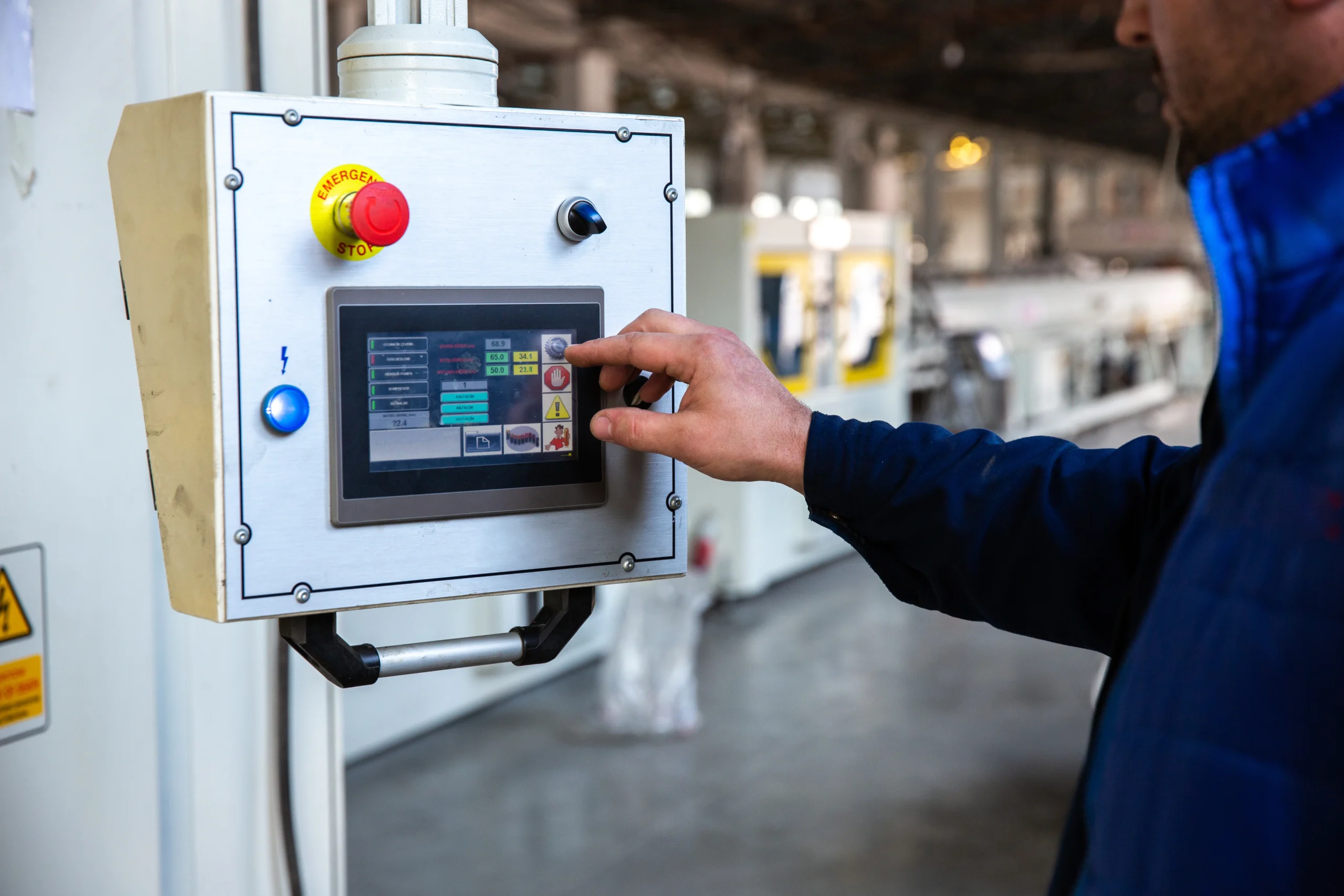 Engineer interacting with a control system touchscreen inside a process facility, symbolizing functional safety verification and common cause failure analysis in action.