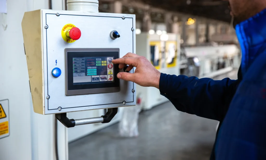 Engineer interacting with a control system touchscreen inside a process facility, symbolizing functional safety verification and common cause failure analysis in action.